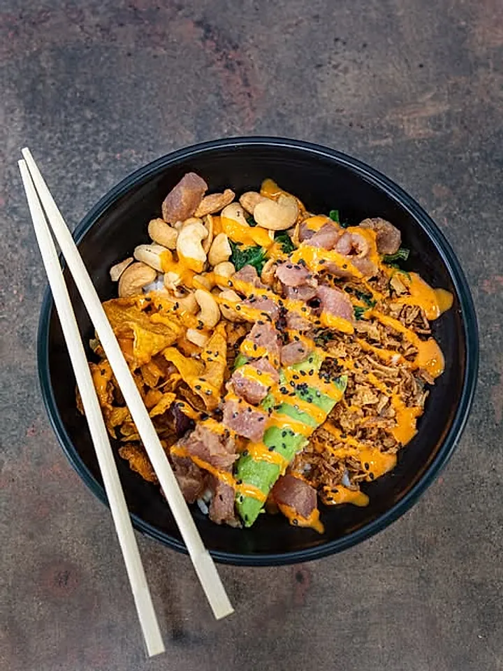 Poke con atún, anacardos y aguacate servido con palillos